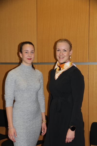 Två kvinnor som fungerar som flerspråkiga handledare på Helsingfors stad. Den ena är klädd i grått den andra i svart. 