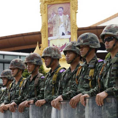 Thailändska soldater, i bakgrunden ett porträtt av kung Bhumibol