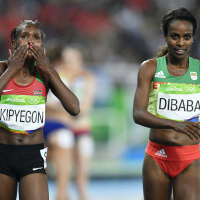 Två kvinnliga afrikanska löpare sida vid sida efter lopp.