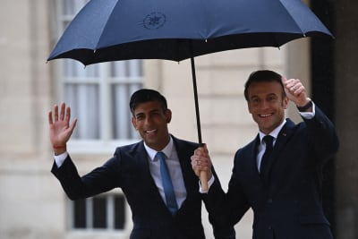 Frankrikes president Emmanuel Macron och Storbritanniens premiärminister Rishi Sunak under ett paraply.
