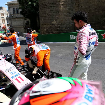 Sergio Perez tittar på då bilen förs iväg