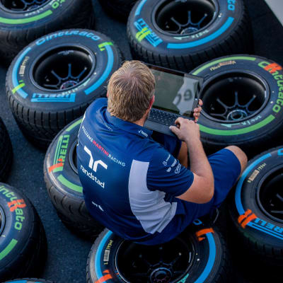 En F1-ingenjör sitter på däck.