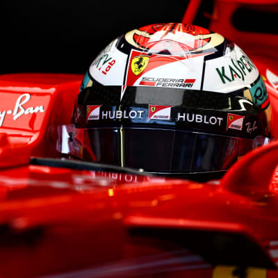 Räikkönen sitter med hjälmen på i bilen.