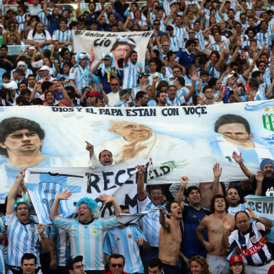 Banner med Maradona, Påven och Messi, under VM-finalen i fotboll.