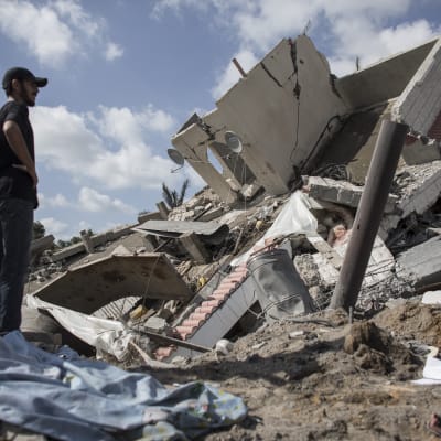 Man i Gaza tittar på ett hus som förstörts av en israelisk raket.