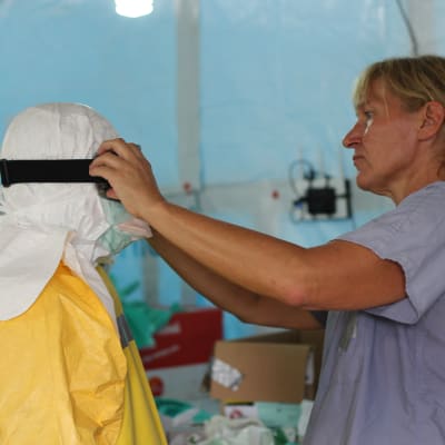svenska sjukskötaren Anneli Eriksson hjälper till med skyddsutrustningen