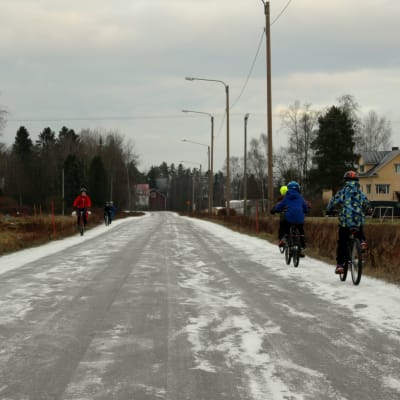 Barn cyklar längs Veikarsvägen i Korsholm