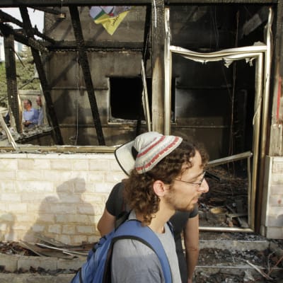 Israeliska fredsaktivister utanför huset till familjen som utsattes för en brandbombsattack  i juli 2015.