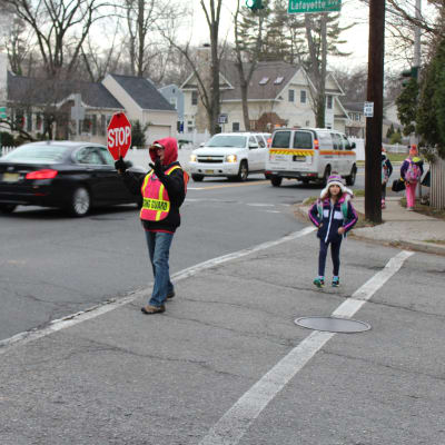 Jennifer Duteil stoppar trafiken medan ett barn går över gatan i Chatham, New Jersey.