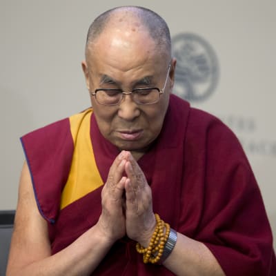 Dalai Lama i röd och gul klädsel ber för offren i Orlando medan han deltar i en direktsänd stream från United States Institute of Peace i Washington om hur man kunde förhindra och stoppa våld.