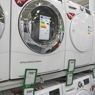 Tvättmaskiner står på rad i butikshyllan.