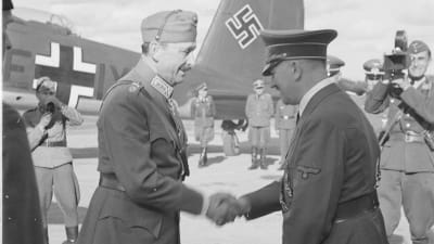 Hitler och Mannerheim skakar hand på flygfältet med ett tyskt plan i bakgrunden.
