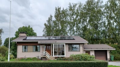 Ett egnahemshus i vit tegel med solpaneler på taket