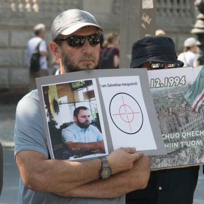 Mielenosoittaja pitelee murhatun Zelimhan Hangošvilin kuvaa.