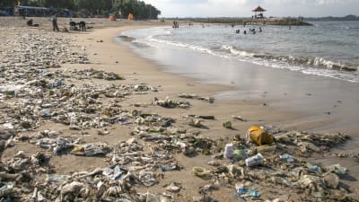 En strand i Bali som är översvämmad av plast
