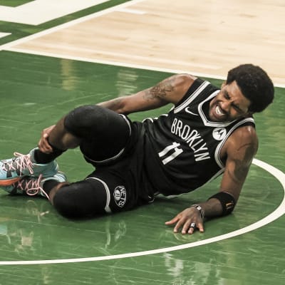 Kyrie Irving makaa loukkaantuneena maassa. 