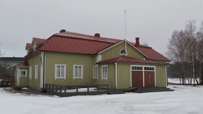 Ljusgrönt föreningshus på vintern.