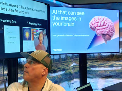 Ett AI-bolags reklamskärm med texten "AI som kan se bilderna i din hjärna". Och en bild av en ljusröd hjärna.