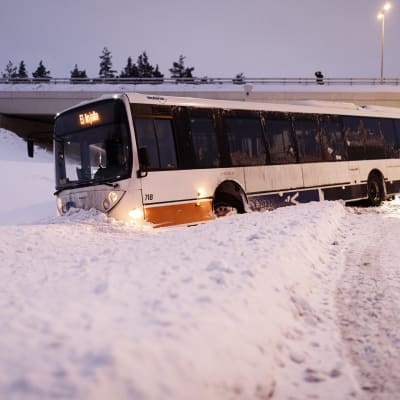 Buss som fastnat i snöhög.