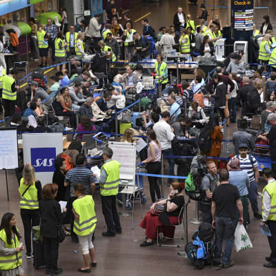 Resenärer väntar på att bli ombokade på Arlanda flygplats i Stockholm den 13 juni 2016 - tiotusentals passagerare påverkas av pilotstrejken.