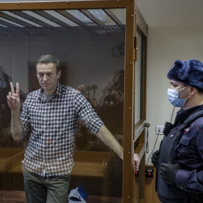 Den ryske oppositionspolitikern Aleksej Navalnyj visade segertecknet i rättegångssalen i Moskva den 20 februari 2021.