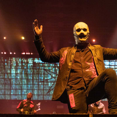 Slipknots sångare Corey Taylor iklädd en vit mask uppträder på scen.