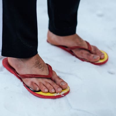 Fötter i flipflops i snö