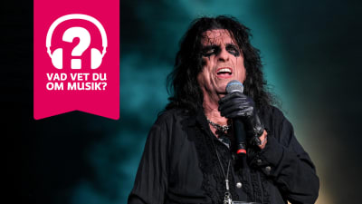 Alice Cooper sjunger i en mikrofon som han håller i handen.