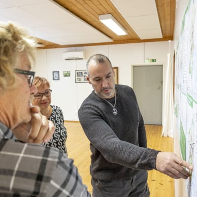 Markku ja Riitta Hyötyläinen, sekä Isto Blomqvist katsovat seinälle ripustettua kaavakarttaa.