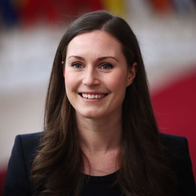 Sanna Marin ler stort när hon anländer till ett EU-möte i Bryssel den 12 december.
