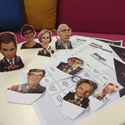 Bild av utskrivna papper med valbingo, valtippningsschema och utklippta karikatyrer av presidentkandidaterna.