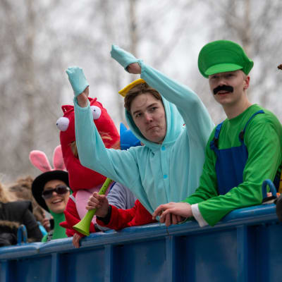 Nuoria penkkariasuissa kuorma-auton kyynnissä. Kuvassa muun muassa Super Mario -pelien Luigi-hahmoksi pukeutunut nuori. Hänen vieressään toinen nuori tuulettaa kädet ilmassa.