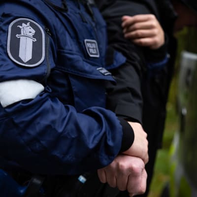 Poliisi pitää kiinni kiinniotetun henkilön kädestä poliisiammattikorkeakoulun poliisiopiskelijoiden rikospaikkaharjoituksessa.