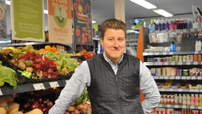 Kristian Eklund står vid fruktdisken inne i sin affär i Korpo.