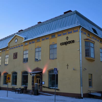 Gräddgult våningshus från 1900-talets början på vintern.