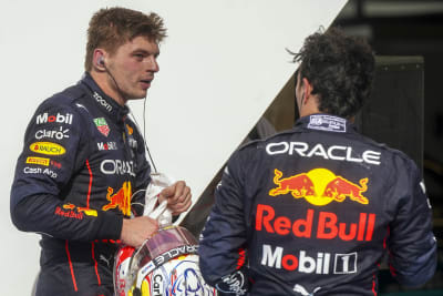 Max Verstappen och Sergio Perez snackar med varandra i depån.