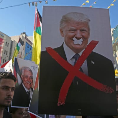 Palestinska demonstranter håller upp ett plakat med Donald Trump. 