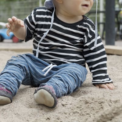 Lapsi leikkii hiekkalaatikolla.