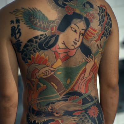 Den tatuerade ryggen på en japansk Yakuzamedlem.