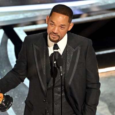 Will Smith står med sin Oscarsstatyett i handen och talar i en mikrofon.