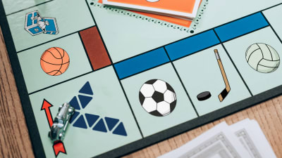 Ett monopolspel med de traditionella symbolerna utbytta till Veikkaus logo, tre bollar och en ishockeyklubba med puck.
