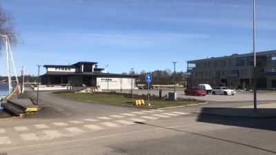 En parkeringsplats framför en restaurang och ett bostadshus i Norra hamnen i Ekenäs.