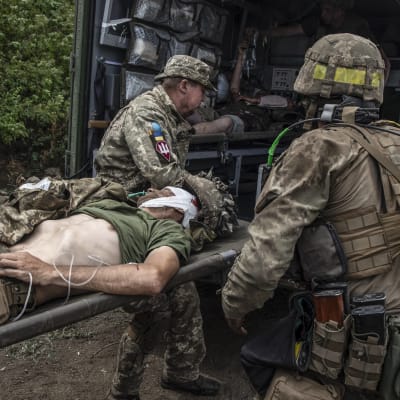 En skadad ukrainsk soldat lyfts in i en ambulans vid fronten.