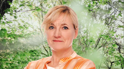 Elli Flén småler mot kameran. I bakgrunden syns en grönskande skogsdunge.