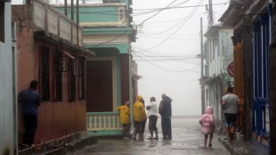 Människor står i regnet i den kubanska kuststaden Baracoa 4.10.2016