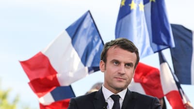 Emmanuel Macron med Frankrikes och EU:s flaggor bakom sig.