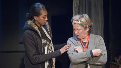 Ujuni Ahmed ja Eija Ahvo vuonna 2012 Kassandrateatterin näytelmässä Mikä elämä! Ujuni Ahmedin esittämä roolihahmo koskettaa epäilevän näköistä Eija Ahvon esittämää naista olkapäähän.