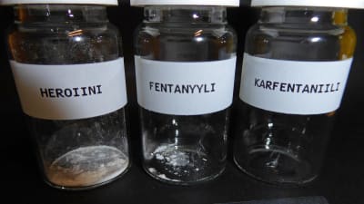 Tre glasburkar innehållandes en dödlig dos av heroin, fentanyl respektive karfentanil.