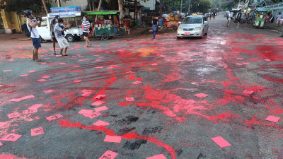 En gata har målats med röd målfärg i protest mot militärkuppen.