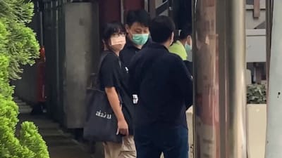 Chow Hang Tung (till vänster) fördes bort av poliser, efter att hon gripits på sin arbetsplats på fredag morgon. 